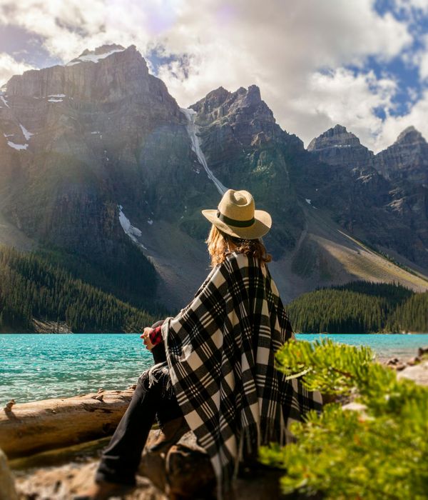 Woman meditating peacefully outdoors by the water.